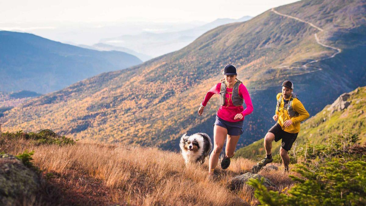 a couple of people running on a mountain